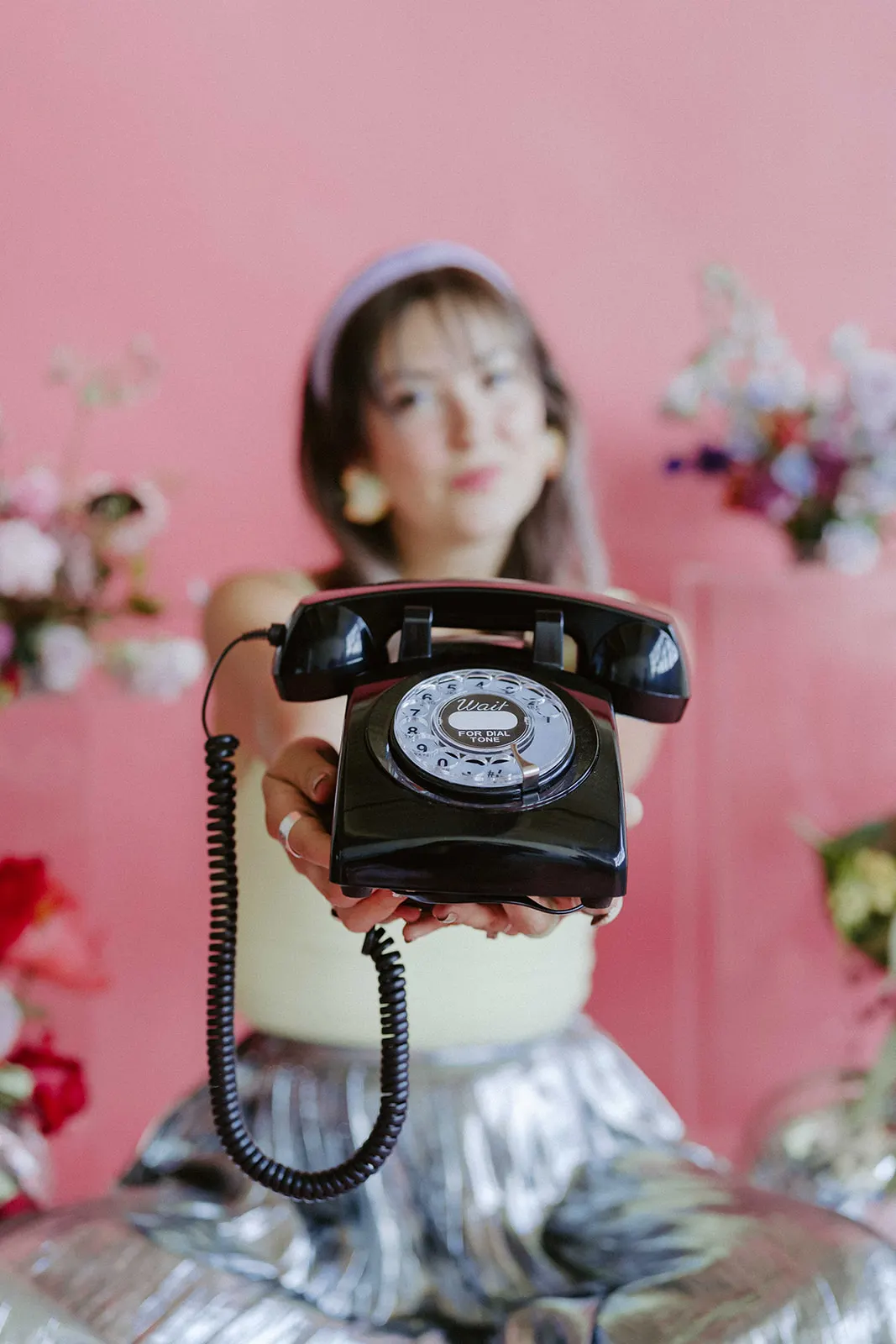 Stephanie answering the audio guestbook phone against a pink backdrop