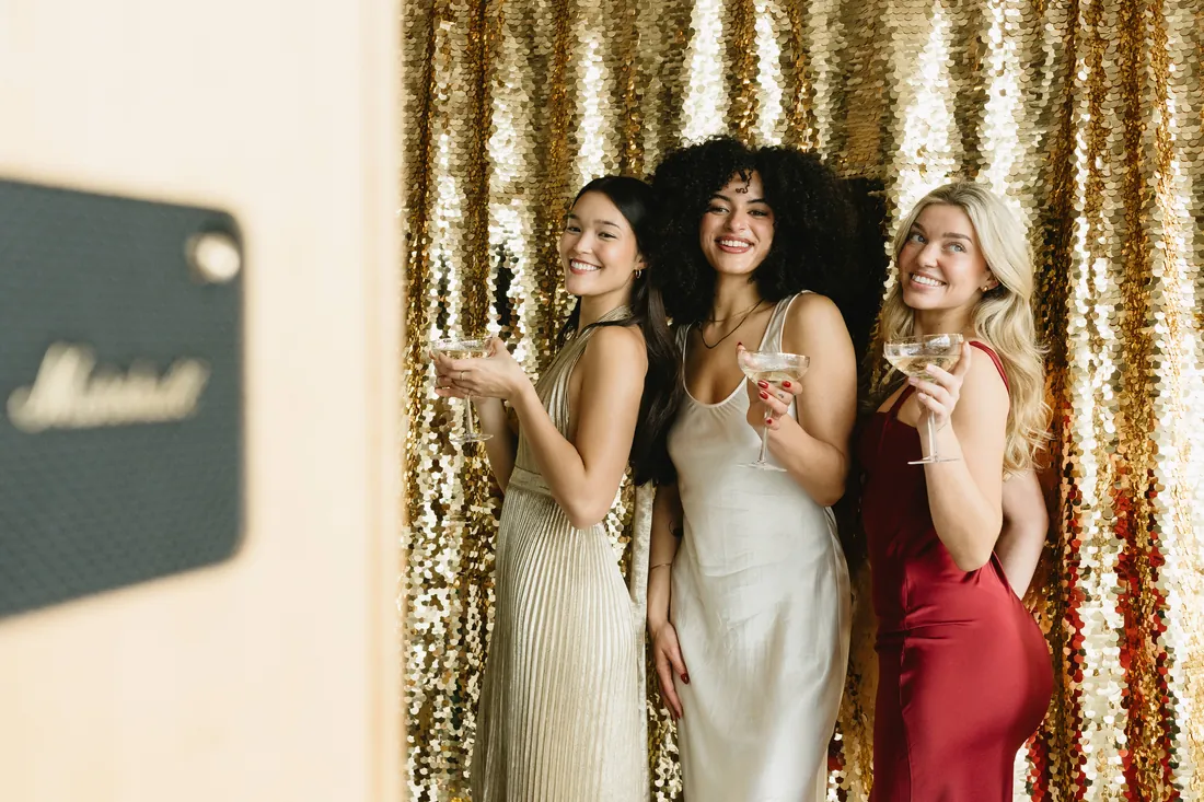 Guest laughing in front of a gold sequin wall