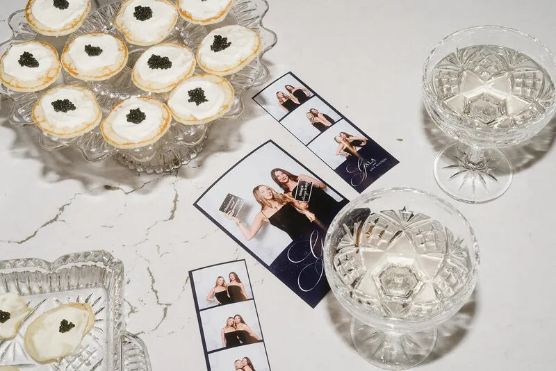 Photo strips scattered beside desserts and coupe glasses
