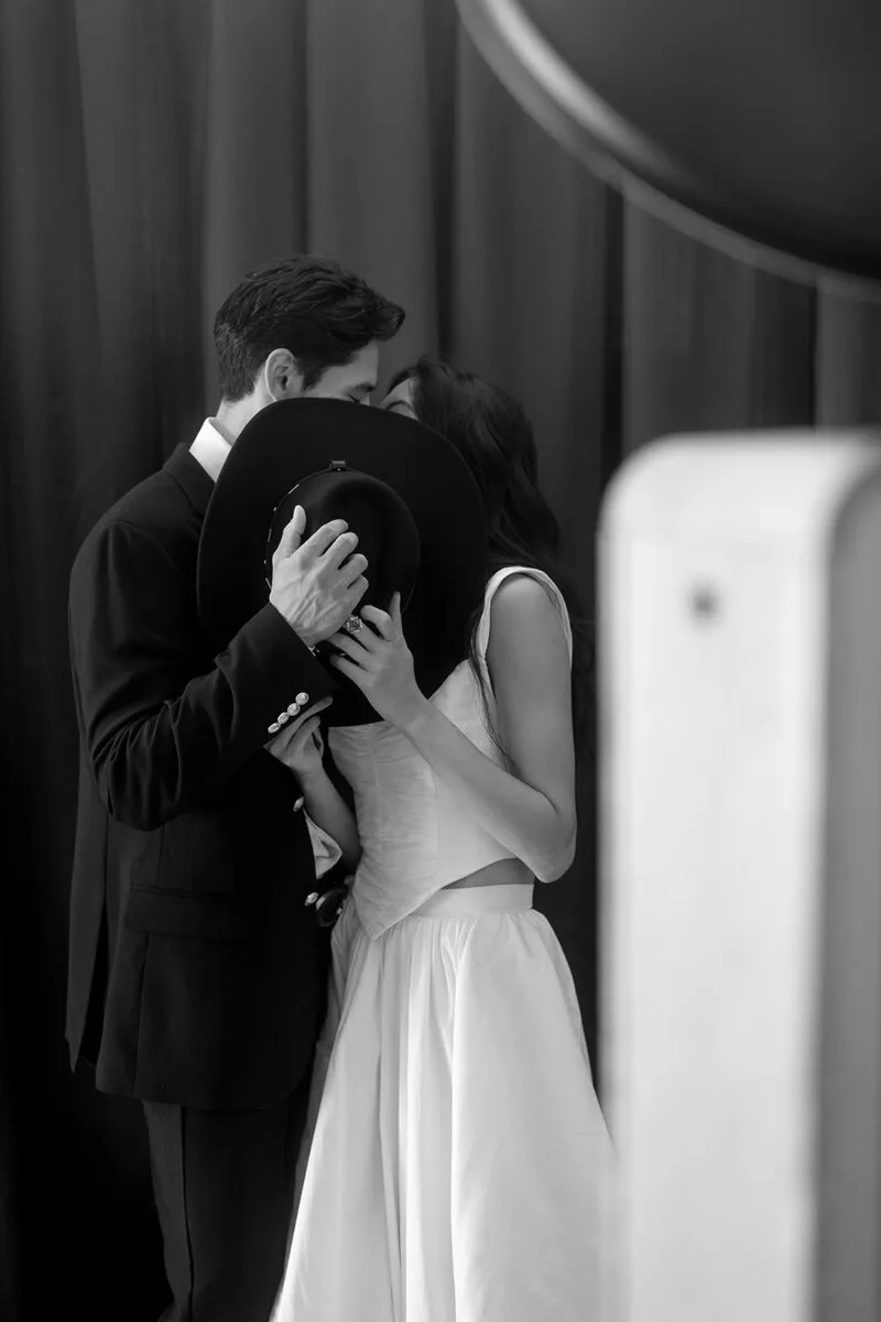 Couple sharing a kiss beside the photo booth.
